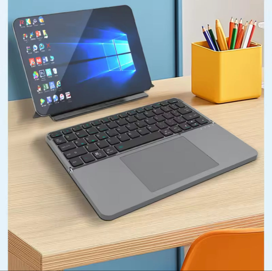 Tablet with keyboard on a desk next to a container of pens